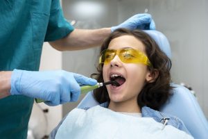 ילדה הוכלת לטיפול שיניים אצל רופא שיניים לילדים
