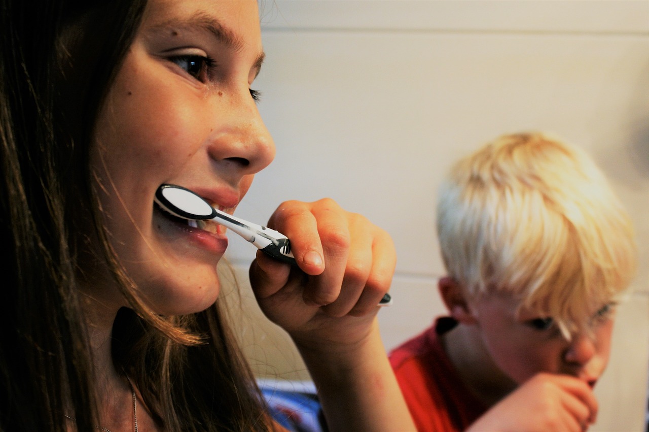 שני ילדים מצחצחים שיניים בערב